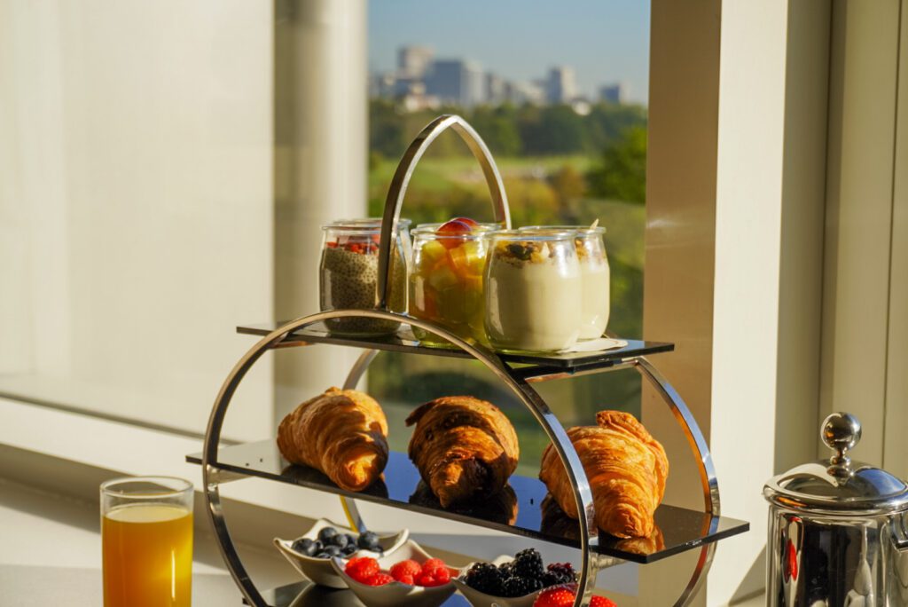 Enjoying breakfast with views onto Kensington Gardens, one of the best free places to visit in London. At the Royal Garden Hotel you can enjoy these views with breakfast in your room, including yoghurt, croissants and fresh orange juice.