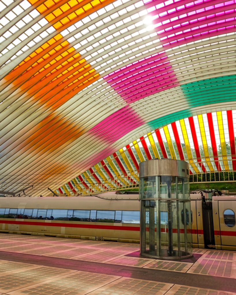 A picture of the stained glass colourful roof in Liege train station. Liege is accessible via direct train from Bruges. Passing through the station is a Deutsche Bahn train