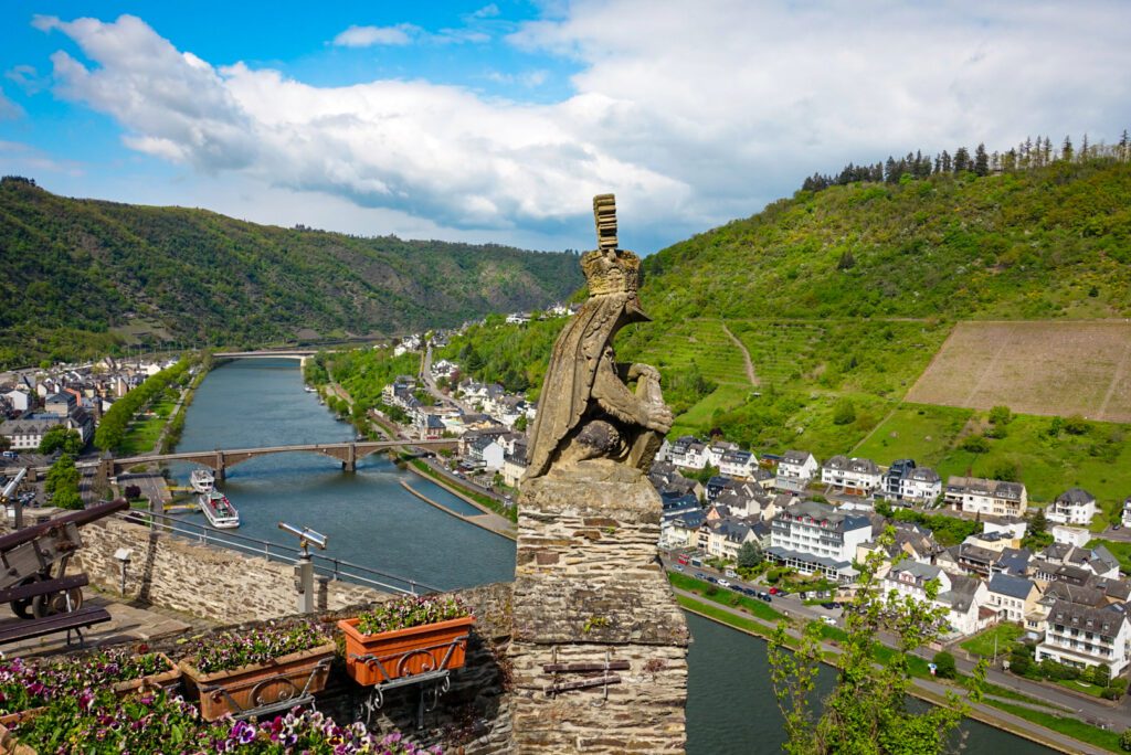 The view from the Reichsburg at Cochem an der Mosel is not only decorated with flower-boxes, however also crowned by a stone figure, looking out onto the Moselle Valley.