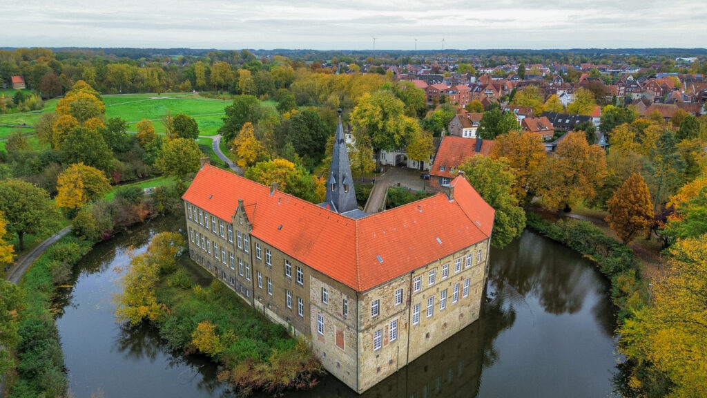 Burg Lüdinghausen is one of three moated castles in the town of Lüdinghausen - the red brick roof stands out prominently in the surrounding landscape. You can visit the inside of the moated castle on weekends, with free guided tours taking place. It has stone walls and a red brick roof.
