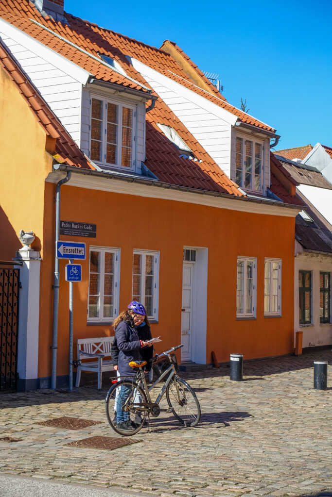 Peder Barkes Gade is a street in Aalborg, lined with colourful houses. The cobbled street leads past the different houses, including ones with bright orange facades.