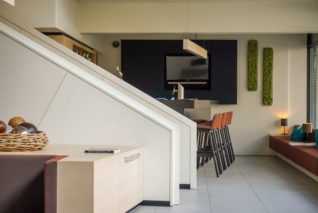 The lobby of the Stadthotel is not only photogenic due to its modern design, but also its architecture. The reception/lobby area is equipped with seating as well as a small bar area with bar stools.